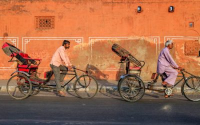 Indian men ride cycle rickshaw on streets of Rajasthan, India.